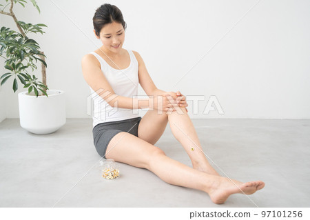 A woman doing moxibustion on her leg 97101256