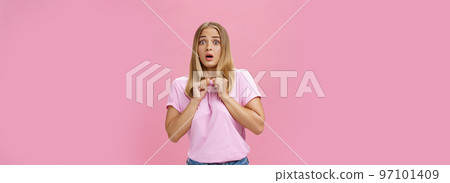 Woman gasping from fright being scared by someone pressing clenched hands to chest bending backwards looking worried and terrified at camera being shocked with unexpected bang over pink wall Woman gasping from fright being scared by someone pressing clenched hands to chest bending backwards looking worried and terrified at camera being shocked with unexpected bang over pink wall 97101409