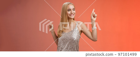 Carefree good-looking stylish glamour blond young 20s woman in silver glittering dress dancing having fun amused go wild party night prom shaking body raising index fingers up, red background Carefree good-looking stylish glamour blond young 20s woman in silver glittering dress dancing having fun amused go wild party night prom shaking body raising index fingers up, red background 97101499