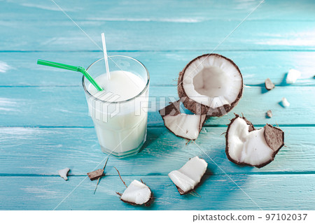 Top view of coconut milk in glass with coconut fruit on wooden table. Alternative milk concept.  97102037
