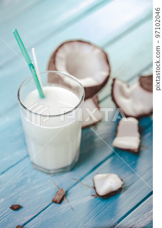 Top view of coconut cocktail in glass with coconut on white wooden table. Selective focus. Tropical 97102046