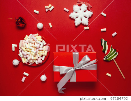 Christmas or winter composition. Cup with coffee, marshmallows, gift and Christmas decor. Flat lay, top view 97104792
