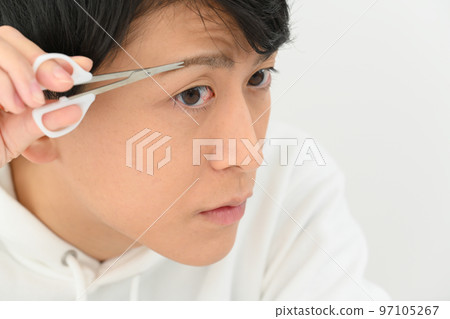 修剪他的眉毛的年輕人 97105267