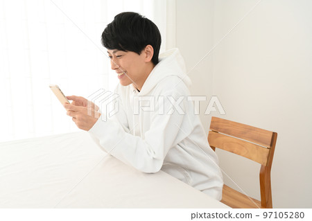 在辦公桌前操作智能手機的年輕人 在辦公桌前操作智能手機的年輕人 97105280