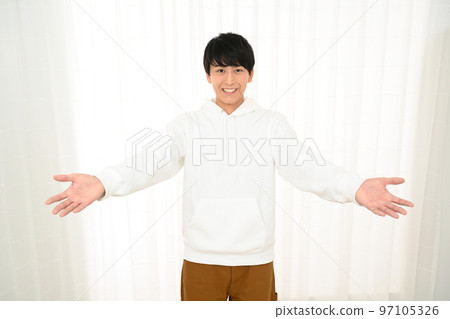 A man in a welcome pose with his hands open 97105326