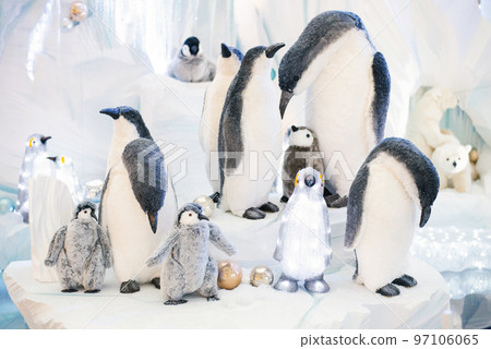 Christmas decor. Ornamental penguins on an artificial iceberg made of snow and ice 97106065