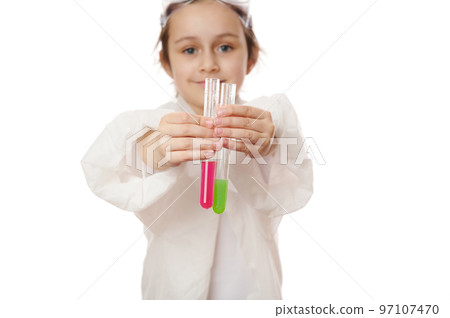 Selective focus on little child's hands holding out test tubes, showing the current chemical reaction with reagents in them to the camera. Miracles of chemistry science, isolated on white background Selective focus on little child's hands holding out test tubes, showing the current chemical reaction with reagents in them to the camera. Miracles of chemistry science, isolated on white background 97107470