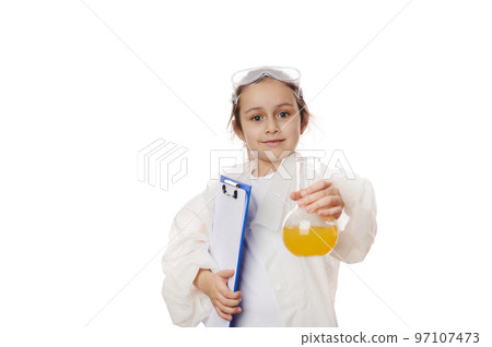 Lovely baby girl, future chemist scientist in lab coat, smiles at camera, holds out a laboratory flask with liquid chemical, isolated on white background. Kids learning chemistry. Education concept Lovely baby girl, future chemist scientist in lab coat, smiles at camera, holds out a laboratory flask with liquid chemical, isolated on white background. Kids learning chemistry. Education concept 97107473