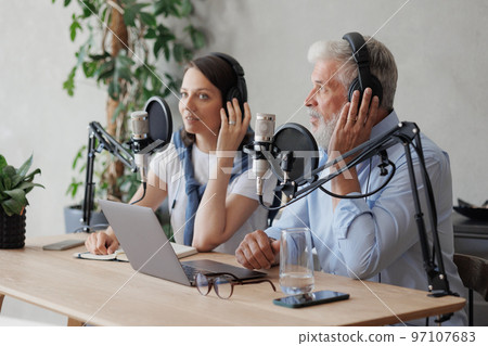 female and male podcasters record audio content in sound studio. social media, news program on radio female and male podcasters record audio content in sound studio. social media, news program on radio 97107683