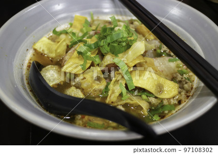 Yellow egg noodles in spicy pork soup 97108302