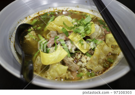 Yellow egg noodles in spicy pork soup 97108303