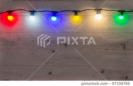 Color lamps garland on the pale wooden background Color lamps garland on the pale wooden background 97108766