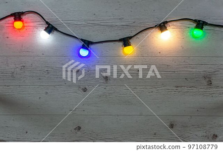 Color lamps garland on the pale wooden background Color lamps garland on the pale wooden background 97108779