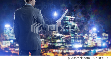 Rear view of businessman against night cityscape background and technology concept Rear view of businessman against night cityscape background and technology concept 97109103