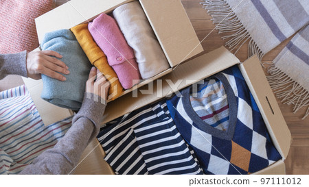 Putting clothes in cardboard | Changing clothes, discarding, and recycling image Putting clothes in cardboard | Changing clothes, discarding, and recycling image 97111012
