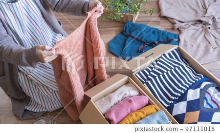 Putting clothes in cardboard | Changing clothes, discarding, and recycling image 97111018
