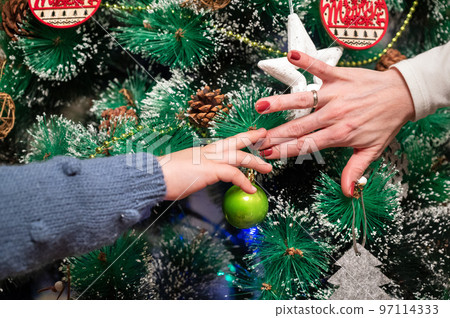 Close up of a Mother And Dughter Decorating Christmas Tree Close up of a Mother And Dughter Decorating Christmas Tree 97114333