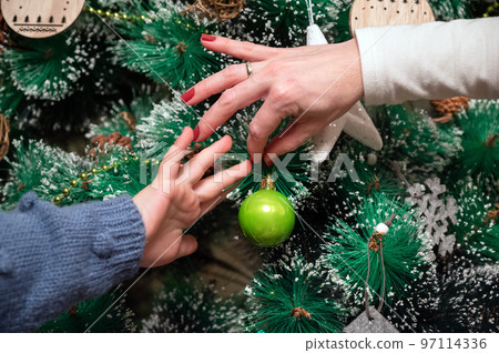 Close up of a Mother And Dughter Decorating Christmas Tree Close up of a Mother And Dughter Decorating Christmas Tree 97114336