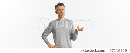 Image of confused middle-aged man cant understand something, raising hand and looking puzzled left, standing clueless over white background Image of confused middle-aged man cant understand something, raising hand and looking puzzled left, standing clueless over white background 97116329
