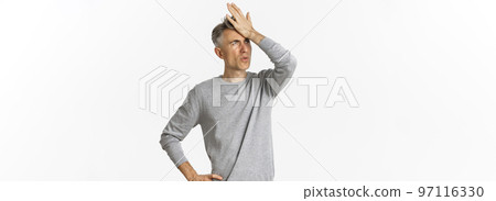 Image of frustrated and distressed middle-aged man, making facepalm and exhaling disappointed, standing over white background Image of frustrated and distressed middle-aged man, making facepalm and exhaling disappointed, standing over white background 97116330