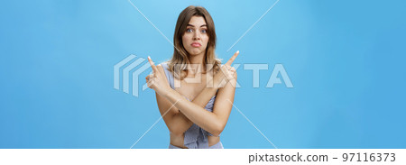 Help girl make hard decision. Portrait of gloomy unsure hesitant cute female model with natural hair and tan crossing hands over body pointing at upper right and left corners with sad uncertain look Help girl make hard decision. Portrait of gloomy unsure hesitant cute female model with natural hair and tan crossing hands over body pointing at upper right and left corners with sad uncertain look 97116373