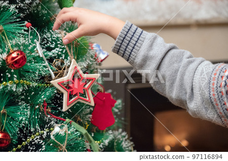 Little boy Decorating Christmas Tree with Ornaments 97116894