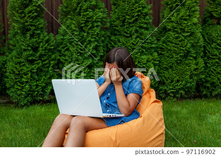 girl with a laptop in the garden 97116902