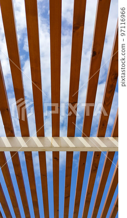 Blue sky through wooden roof beams Blue sky through wooden roof beams 97116966