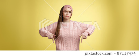 Why me, gosh. Gloomy upset complaining cute glamout young european girl in casual sweater, headband frowning, whining grimacing displeased pointing down, unhappy see lots work over yellow wall Why me, gosh. Gloomy upset complaining cute glamout young european girl in casual sweater, headband frowning, whining grimacing displeased pointing down, unhappy see lots work over yellow wall 97117474