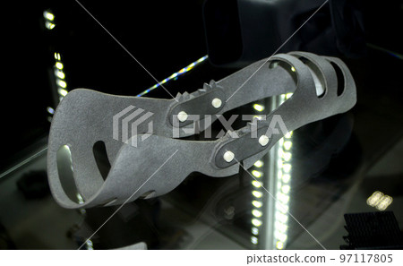Gray orthopedic plastic prosthesis printed on powder 3D printer for cubit hand. Orthopedic gypsum helmet closeup. Multi Jet Fusion MJF 3D printing technology. New modern progressive additive technolog Gray orthopedic plastic prosthesis printed on powder 3D printer for cubit hand. Orthopedic gypsum helmet closeup. Multi Jet Fusion MJF 3D printing technology. New modern progressive additive technolog 97117805