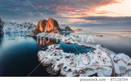 Landscape of aerial view of snowy mountain and fishing village on coastline in winter at Lofoten Islands 97118704