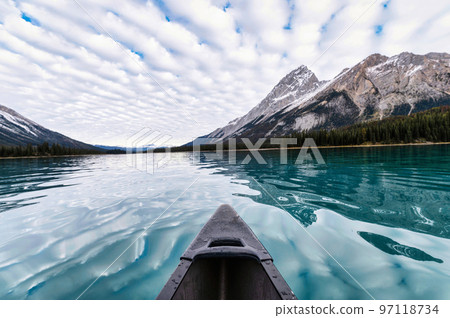 Canoeing on Maligne Lake with Rocky Mountains and cloudy sky in Jasper national park Canoeing on Maligne Lake with Rocky Mountains and cloudy sky in Jasper national park 97118734