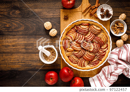 Apple pie. Tart with apples, cinnamon and walnuts. Top view Apple pie. Tart with apples, cinnamon and walnuts. Top view 97122457