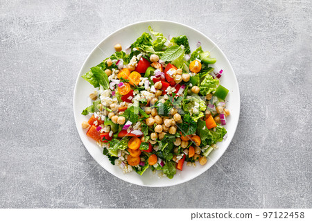 Tabbouleh salad. Tabouli salad with fresh parsley, onions, tomatoes, bulgur and chickpea. Healthy vegetarian food, mediterranean diet. Top view Tabbouleh salad. Tabouli salad with fresh parsley, onions, tomatoes, bulgur and chickpea. Healthy vegetarian food, mediterranean diet. Top view 97122458