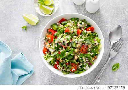 Tabbouleh salad. Tabouli salad with fresh parsley, onions, tomatoes, bulgur and chickpea. Healthy vegetarian food, mediterranean diet. Top view Tabbouleh salad. Tabouli salad with fresh parsley, onions, tomatoes, bulgur and chickpea. Healthy vegetarian food, mediterranean diet. Top view 97122459