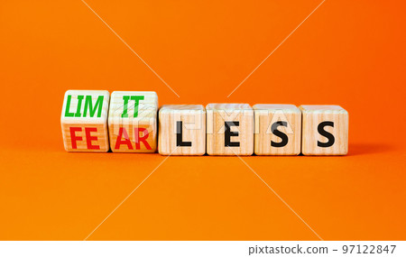 Fearless and limitless symbol. Concept word Fearless and limitless on wooden cubes. Beautiful orange table orange background. Business fearless and limitless concept. Copy space. 97122847