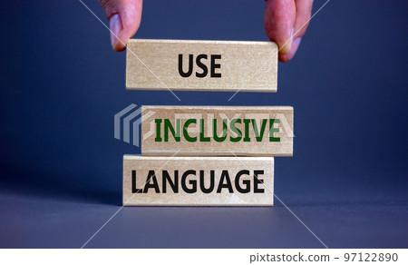 Use inclusive language symbol. Wooden blocks with words 'Use inclusive language'. Beautiful grey background, businessman hand. Business and use inclusive language concept. Copy space. 97122890