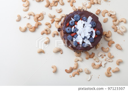 Vegan chocolate beet cake with blackberries, decorated with nuts and seeds coconut top view on white Vegan chocolate beet cake with blackberries, decorated with nuts and seeds coconut top view on white 97123307