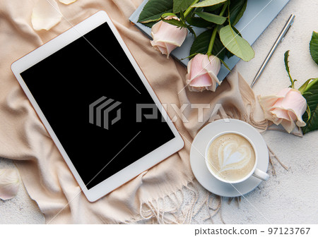 Top view a cup of coffee latte art heart shape with a pink rose and tablet Top view a cup of coffee latte art heart shape with a pink rose and tablet 97123767