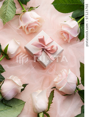 Top view of pink roses and gift box on pink tulle background. Top view of pink roses and gift box on pink tulle background. 97123768