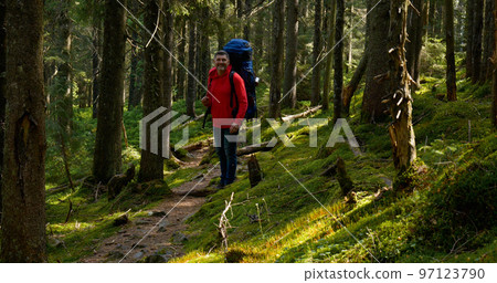 Tourist guy with backpack hiking on an adventure trip in natural landscape Tourist guy with backpack hiking on an adventure trip in natural landscape 97123790