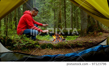 Bearded man by the fire in a beautiful forest. Bearded man by the fire in a beautiful forest. 97123796