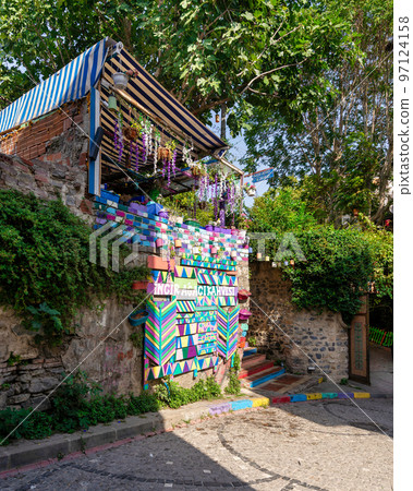 Daytime of cafe decorated with multicolored panels colorful stairs, and canopy in Balat District, Istanbul, Turkey 97124158