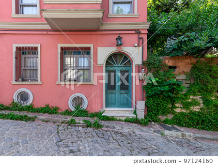 Old house painted in orange, wrought iron windows, and trees, at a cobblestone street, Balat district, Istanbul, Turkey Old house painted in orange, wrought iron windows, and trees, at a cobblestone street, Balat district, Istanbul, Turkey 97124160