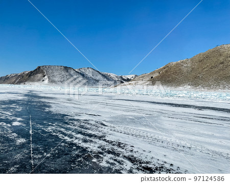 Texture of beautiful blue ice with cracks and air bubbles in the frozen lake. Texture of beautiful blue ice with cracks and air bubbles in the frozen lake. 97124586