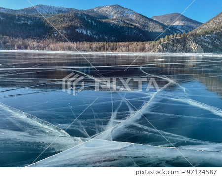 Texture of beautiful blue ice with cracks and air bubbles in the frozen lake. Texture of beautiful blue ice with cracks and air bubbles in the frozen lake. 97124587