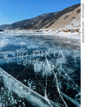 Texture of beautiful blue ice with cracks and air bubbles in the frozen lake. Texture of beautiful blue ice with cracks and air bubbles in the frozen lake. 97124588