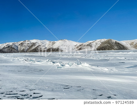 Texture of beautiful blue ice with cracks and air bubbles in the frozen lake. Texture of beautiful blue ice with cracks and air bubbles in the frozen lake. 97124589