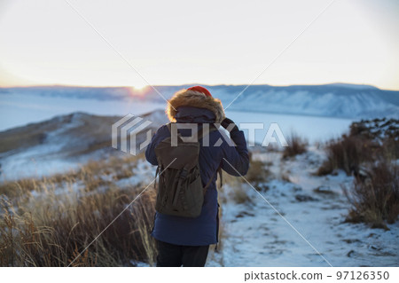 Young man standing in winter frozen nature. Ogoy island, lake Baikal, Siberia, Russia 97126350