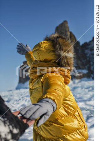 Happy couple on the frozen winter Lake Baikal 97126512